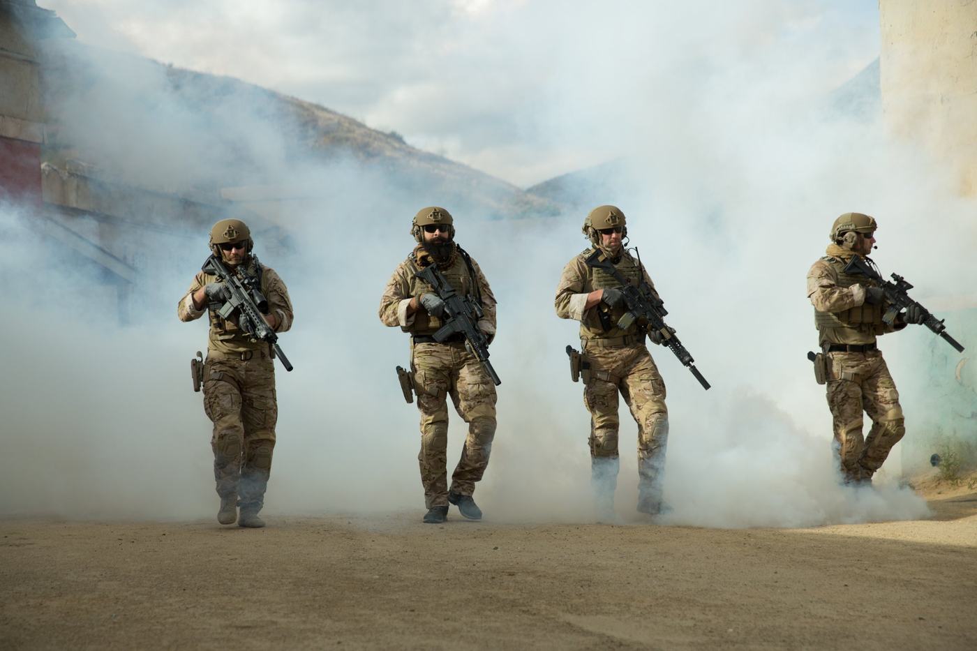 Equipe militar em deslocamento em meio a fumaça